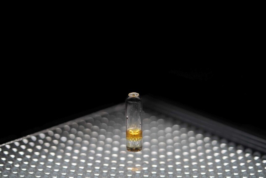 a yellow substance in small vial.