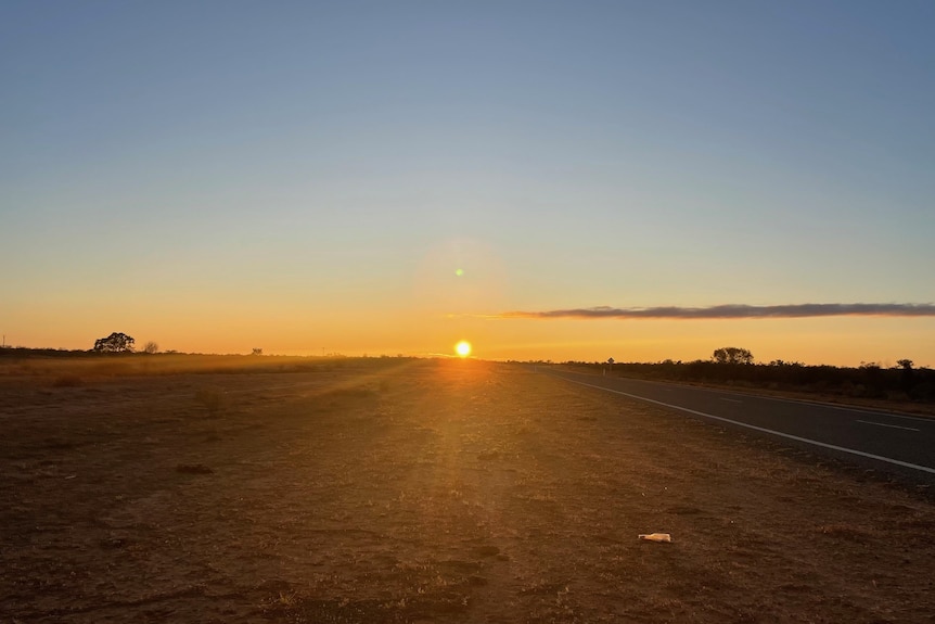A sunset over an outback road 