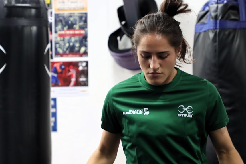 A female boxer, Tiana Echegaray, is skipping and looking down as she trains in the gym.