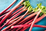 A pile of rhubarb on a blue surface.