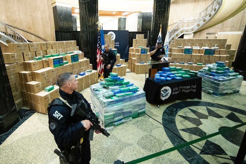 Armed police stand guard next to a fraction of the 15 tonnes of cocaine seized in a Philadelphia raid.