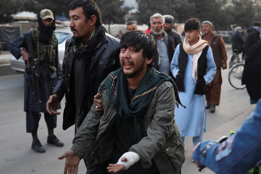 An Afghan man cries as he looks for his relative after a blast in Kabul, November 2021.