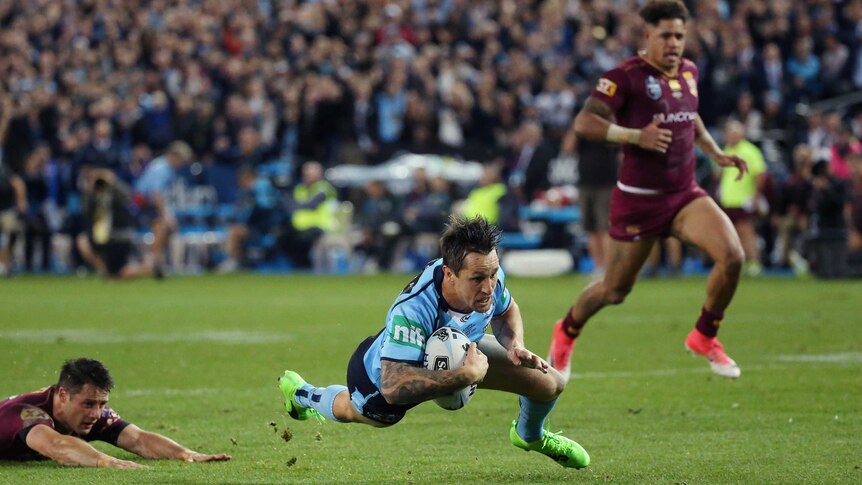 Mitchell Pearce of the Blues dives with the ball to score.