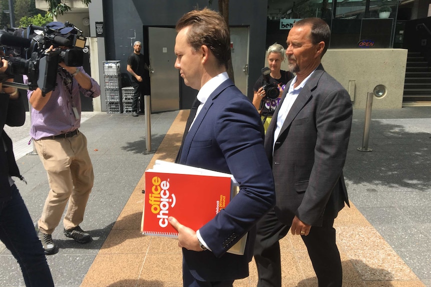 Scott Volkers leaving Brisbane Magistrates Court with his lawyer.