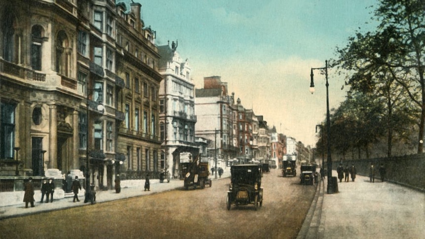 A colour image from the Victorian era of Piccadilly, London, with motor vehicles and pedestrians