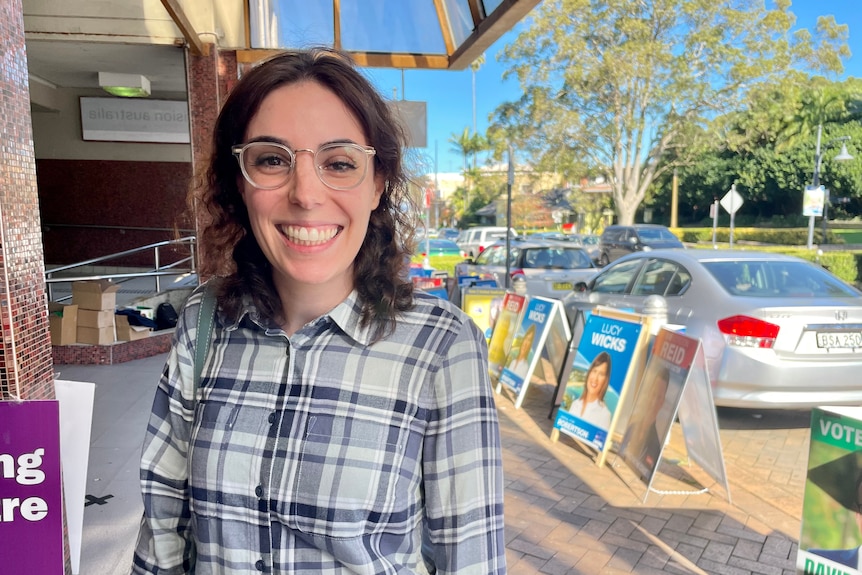 A younger woman smiles at the pre-poll station