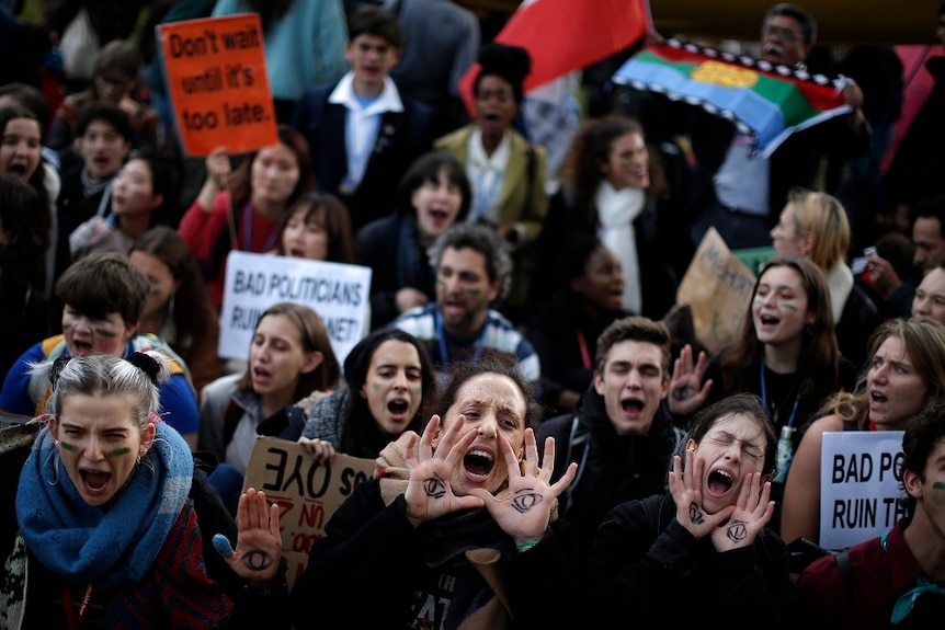 Protesters with sign screaming slogans.