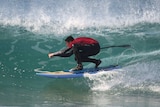 Surfer rides a wave in Tasmania