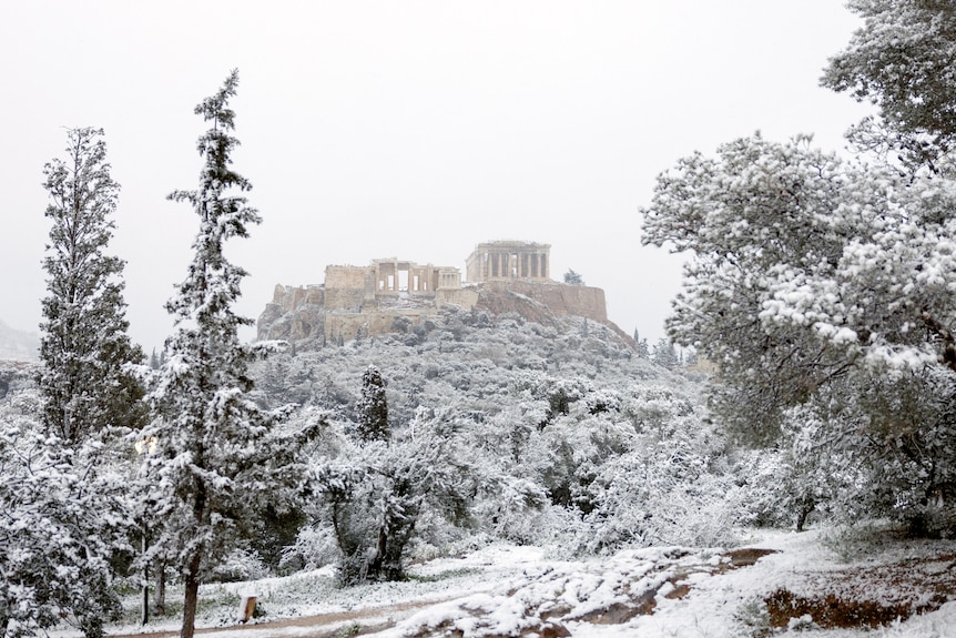 A view of the Parthenon temple atop the Acropolis hill during snowfall in Athens,.