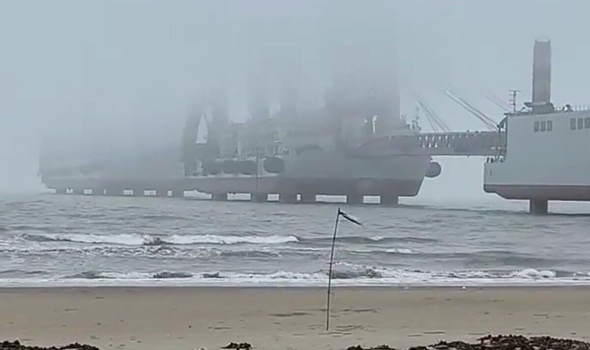 A photo taken from the shoreline of a beach in China showing a landing barge in fog