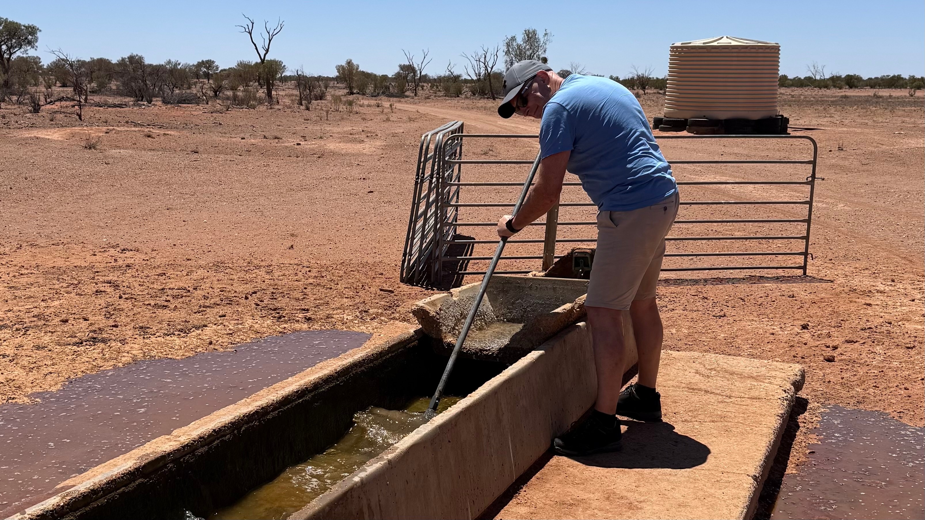 Um homem com uma vassoura fica em frente ao interior durante a limpeza