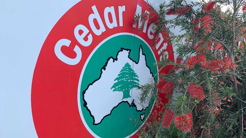 A close-up photograph of the Cedar Meats Australia logo, next to a bottlebrush tree.