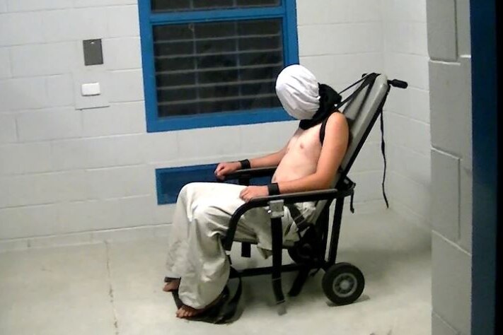 Man in jail with spit hood over head