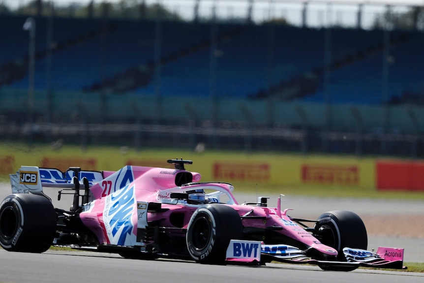 A pink F1 racing car is seen on a race track