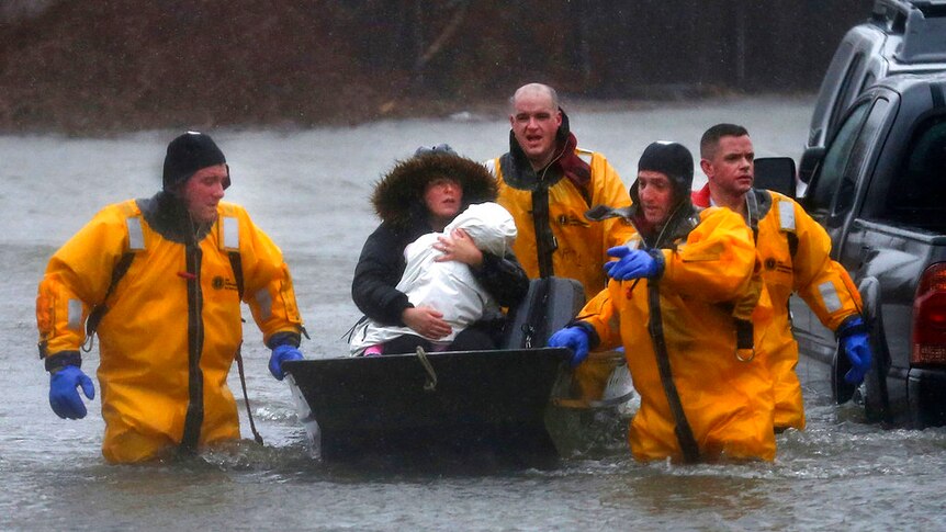 Quincy firefighters rescue a mother and child by boat after their residence was flooded.