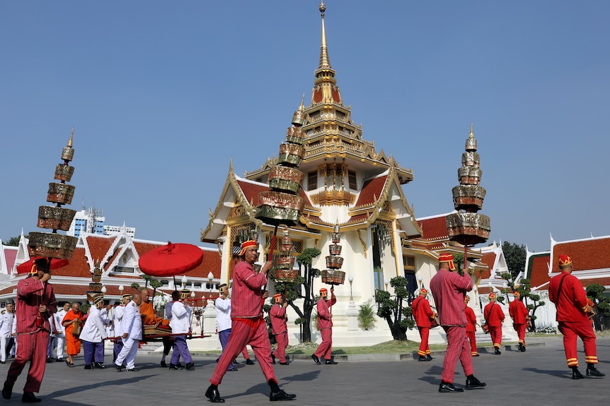 Monks proceed outside the temple to Leicester City owner's funeral