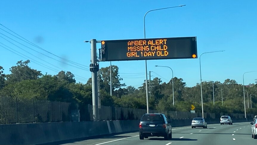 A sign over the motorway reads "amber alert, missing child, girl, one day old"
