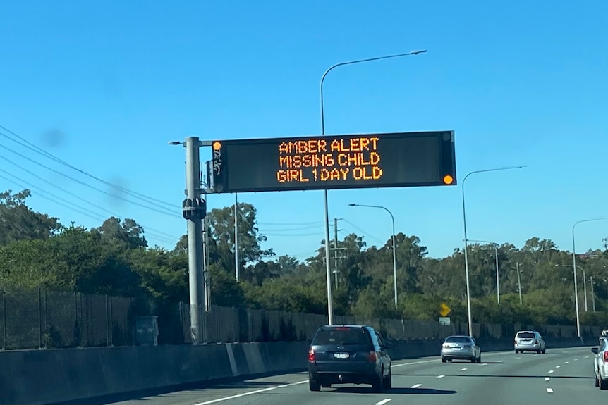 A sign over the motorway reads "amber alert, missing child, girl, one day old"