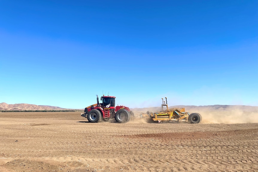 A tractor levelling farmland in the Ord