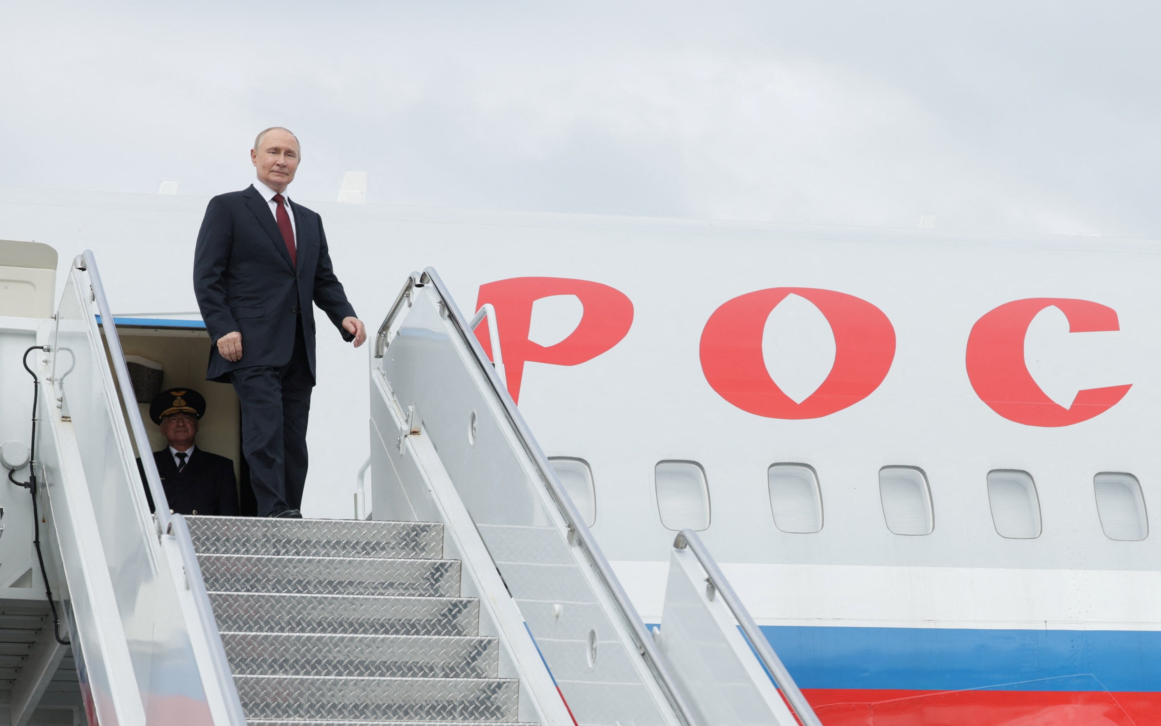 Putin stands at the door of his plane 
