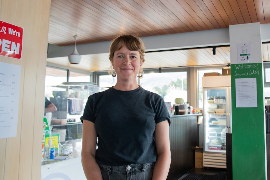 Woman stands in commercial kitchen.