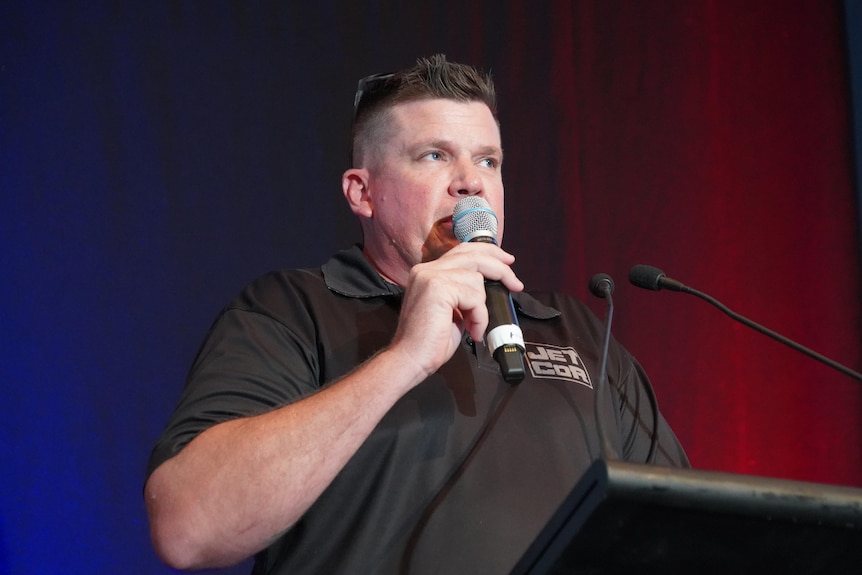 a man in a black shirt holds a microphone