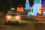 car with its reverse lights on in front of a sign reading no entry into tunnel