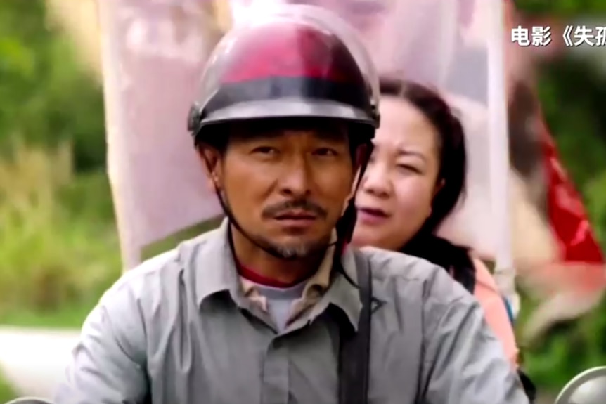 A man and woman on a motorbike.