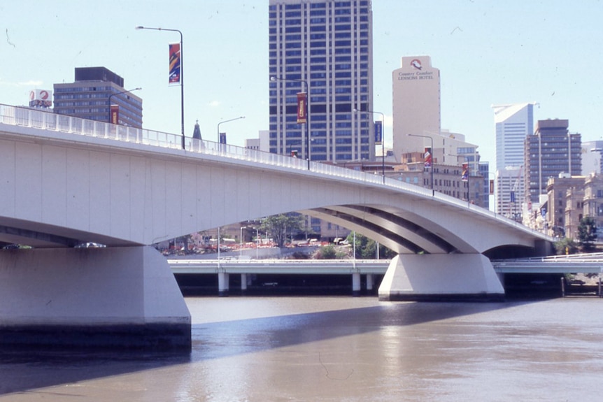 The concrete span of the Victoria Bridge stretches over the Brisbane River, view towards the city.