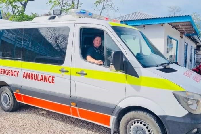 A picture of an ambulance with woman in drivers seat 