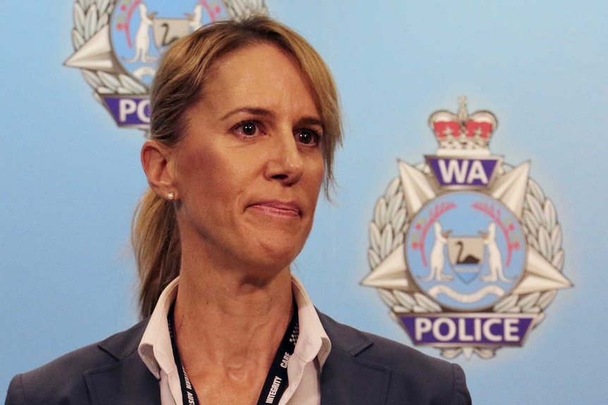 A police officer at a press conference with WA Police logos behind her.