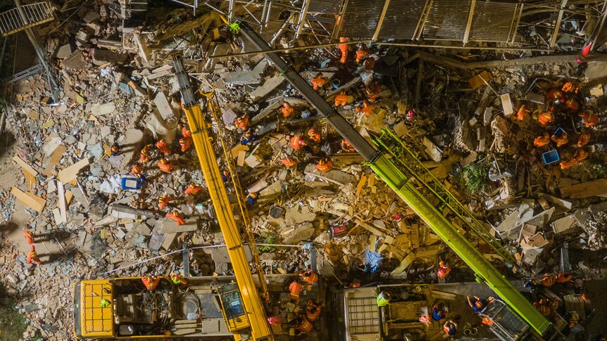 A smattering of rescue workers are seen in aerial view as they work through the rubble in Suzhou City.