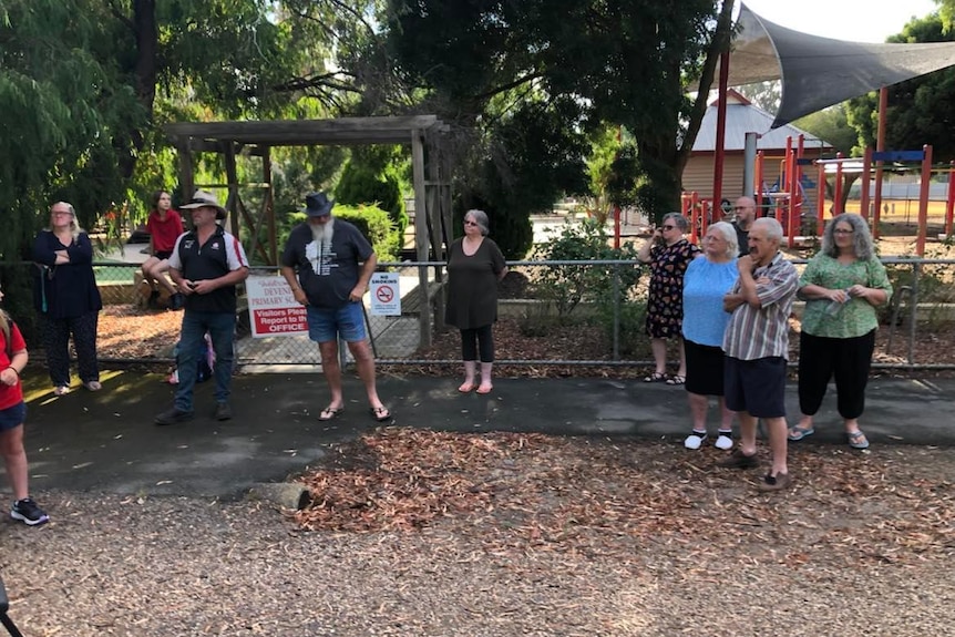 group of people standing at front of school 