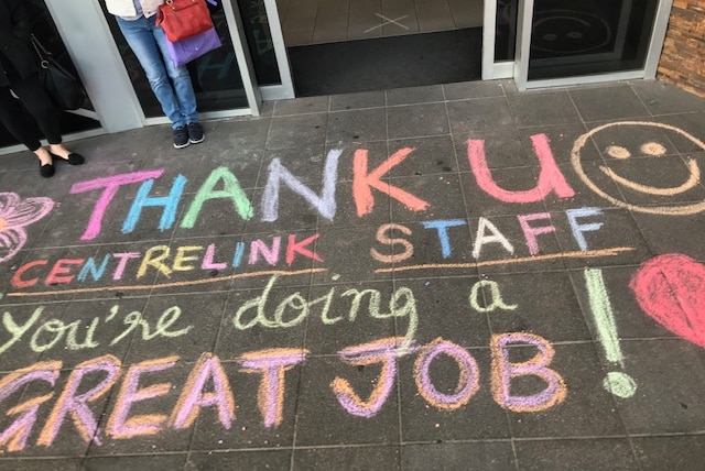 A colourful chalk message saying 'thank u Centrelink staff'.