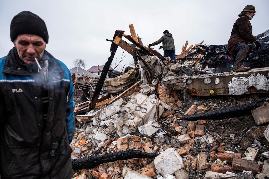 Local residents work among remains of a residential building destroyed by shelling