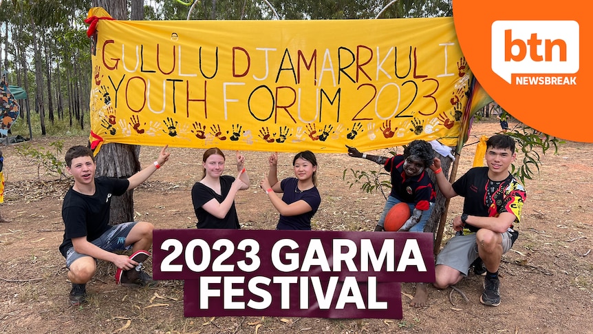 Kids standing in front of a sign at the Garma festival 