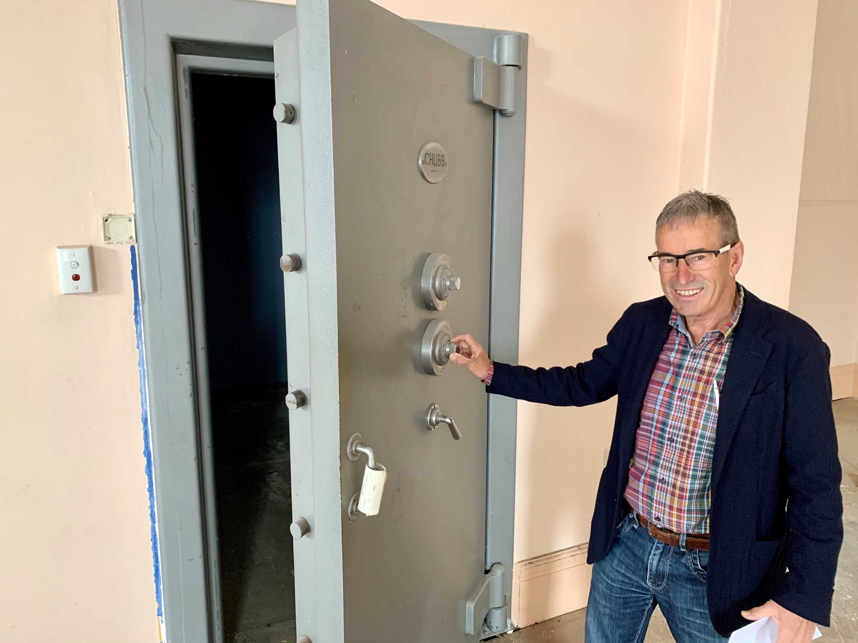 Kevin Coote stands next to the 90 year old Chubb safe he discovered while renovating the bank