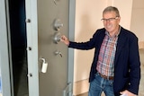 A man stands next to a 90 year old Chubb safe he discovered while renovating a bank building