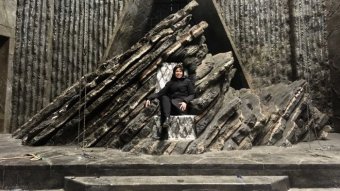 Australian production designer Deborah Riley sits on the Dragonstone Throne from Game of Thrones