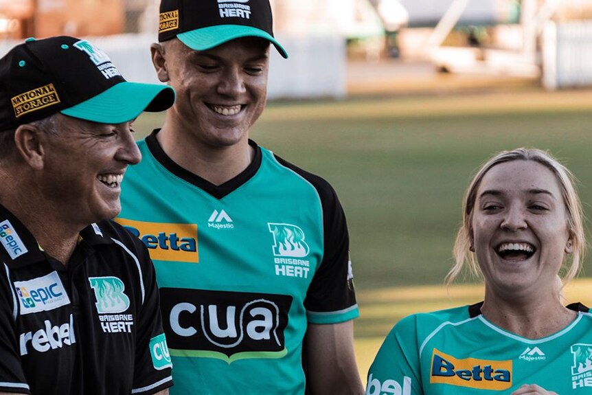 Scott, Jack and Georgia Prestwidge smile and laugh together while wearing their Brisbane Heat gear