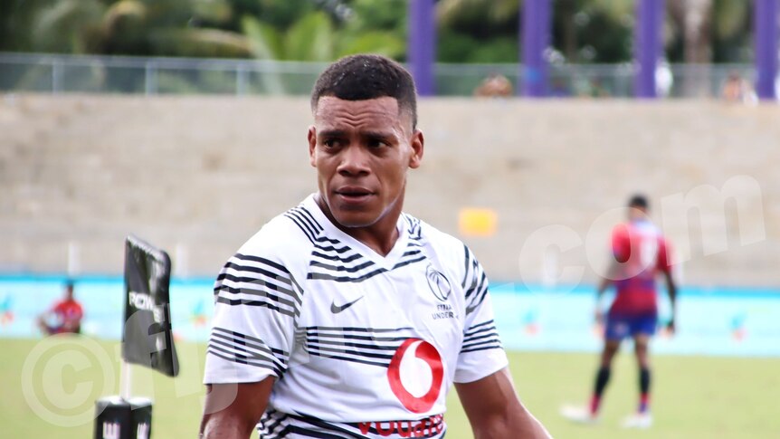 A Fiji rugby player on a football field.