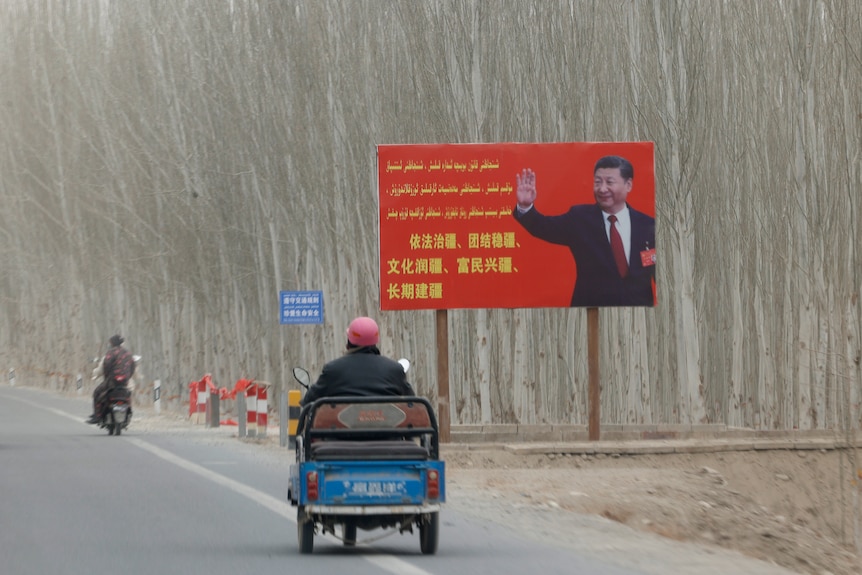 Chinese President Xi Jinping is seen on a billboard with slogans