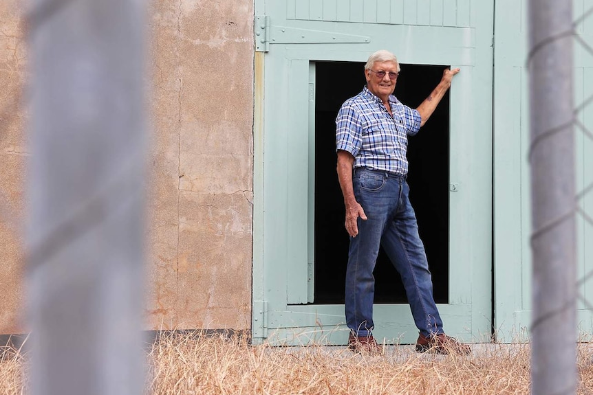 A photo of historian Trevor Horman leaning into the door of an old building.