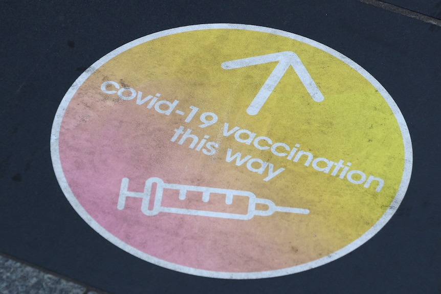 COVID vaccination sticker on a footpath in Melbourne CBD
