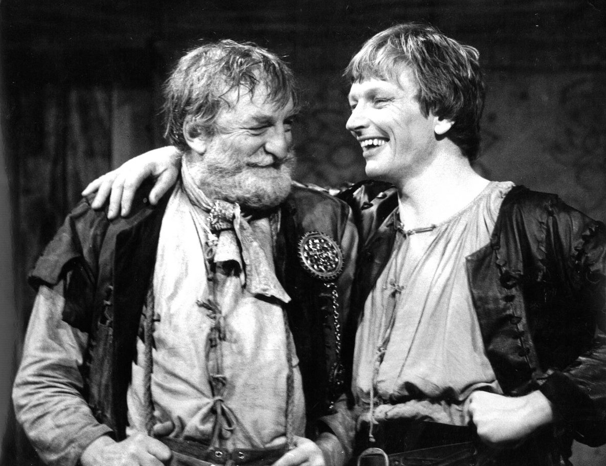 Black and white historical photograph of two male theatre actors laughing
