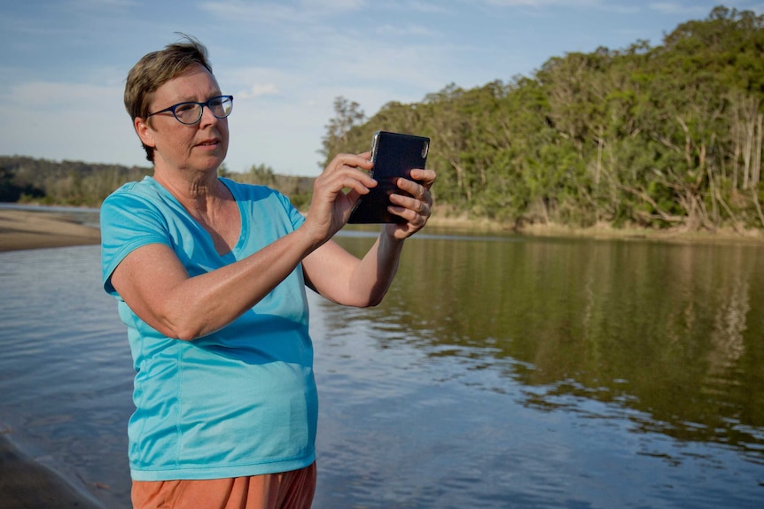 A woman taking photos with an iPhone