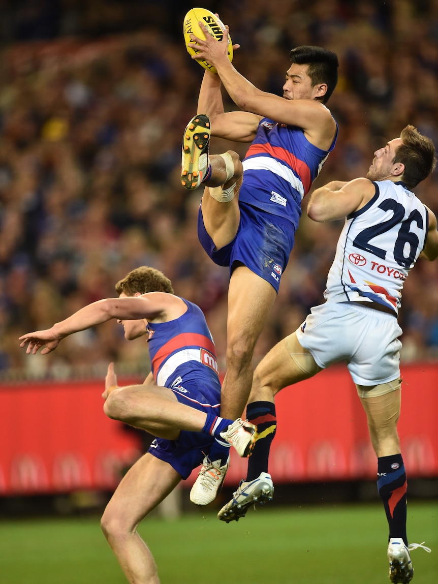 Lin Jong jumps to catch the ball during a game, his leg outstretched towards the camera