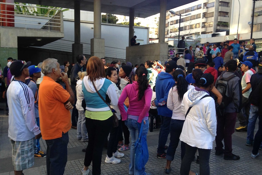 People in Caracas, Venezuela, wait in a long queue for government-issued food rations.