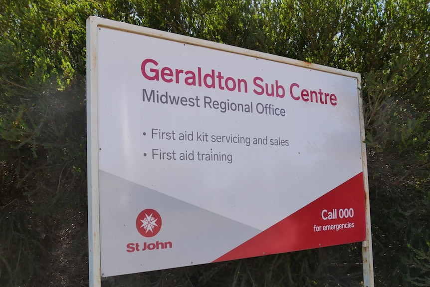 A white and red St John sign planted against a leafy tree saying Geraldton Sub Centre Midwest Regional Office.