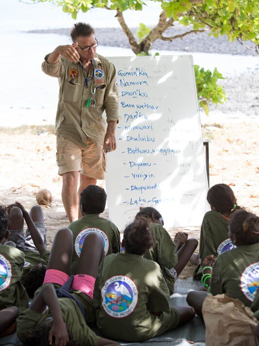 A man in a ranger's outfit speaking with rangers.